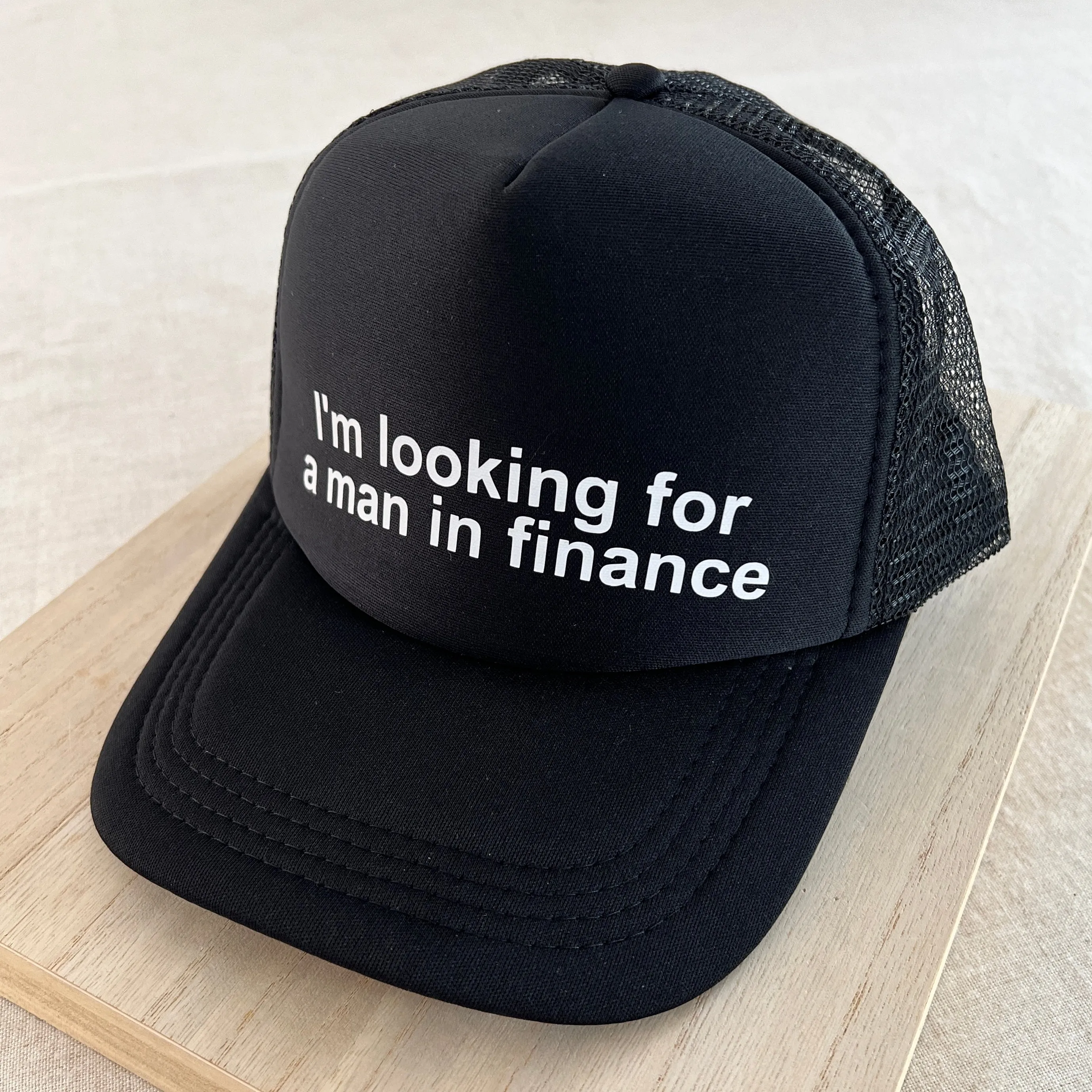 Looking For A Man In Finance Trucker Hat - Black